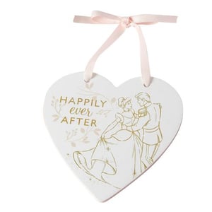 A heart-shaped plaque with Cinderella and Prince Charming dancing on it.