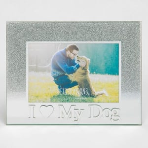 A man is kneeling down next to a dog in a picture frame that says "I love my dog."