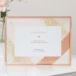 A picture frame is sitting on a table next to a vase of flowers.