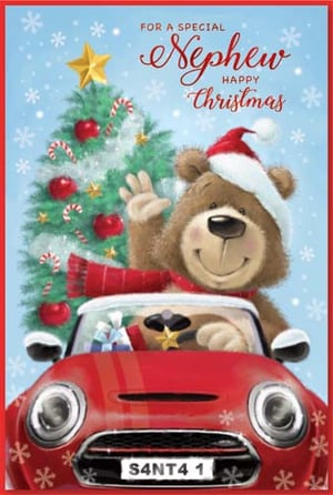 A teddy bear is driving a red car with a Christmas tree in the background.