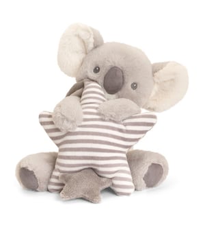 A stuffed koala bear is holding a striped star.