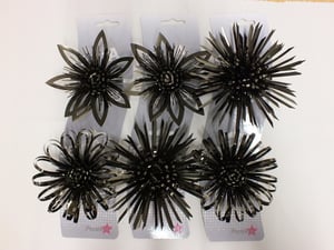 Three packages of black flowers with a pink star on each of them.