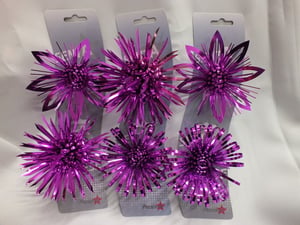 Three packages of purple tinsel is sitting on a white surface.