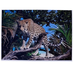 A leopard stands on a tree branch in the jungle.