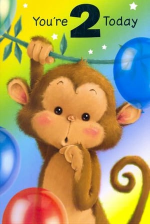 A monkey is hanging from a branch with balloons.