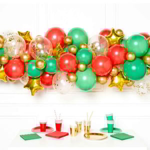 A table with red, green, and gold balloons on it.