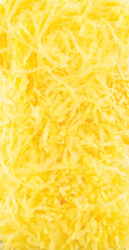 A pile of yellow shredded paper is on a white surface.