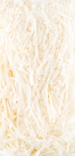 A close-up of shredded coconut is shown on a white background.