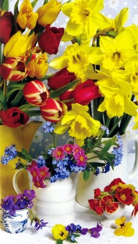 A vase filled with yellow and red flowers sits on the table.