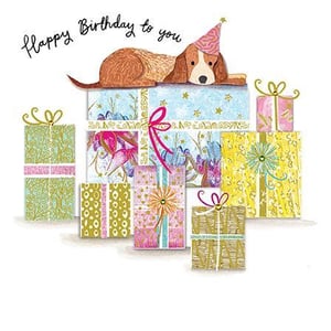 a dog is laying on top of a pile of birthday presents .