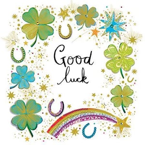 a good luck card with clovers , horseshoes , a rainbow and stars .