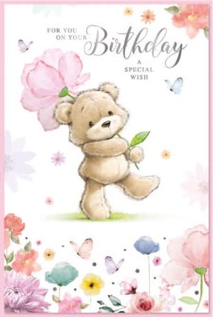 a teddy bear is holding a pink flower on a birthday card .