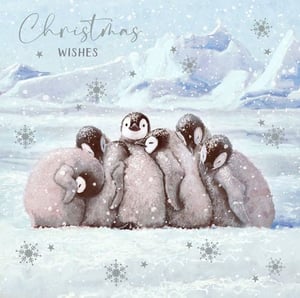a group of penguins are huddled together in the snow on a christmas card .