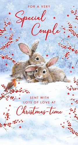 two rabbits are laying in the snow on a christmas card .