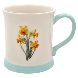a white mug with yellow and orange flowers on it