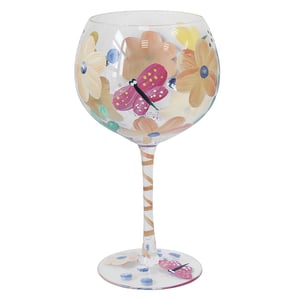 a wine glass with flowers and butterflies painted on it