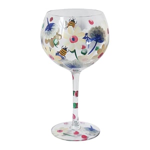 a wine glass with flowers and bees painted on it