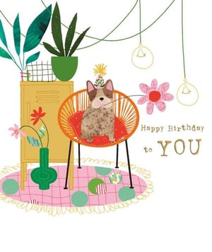 a dog is sitting in a chair wearing a party hat .