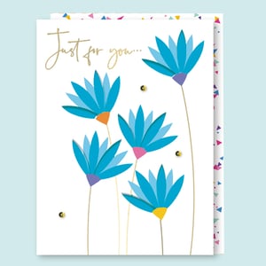 a card with blue flowers and the words just for you