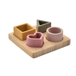 a wooden tray with four different shaped blocks on it .