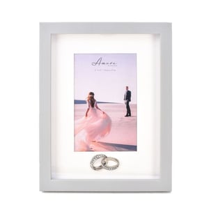 a picture frame with a picture of a bride and groom and two wedding rings .