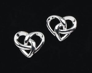 a pair of silver heart shaped stud earrings on a black background .