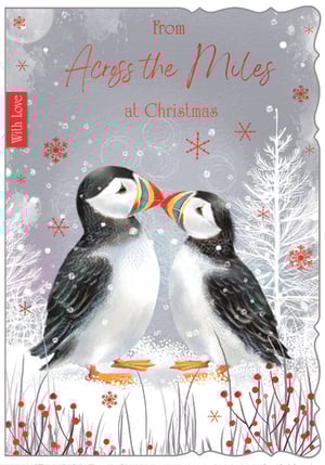 Send warm wishes this Christmas with our delightful 'Across The Miles' card, featuring two charming puffins sharing a tender moment in a snowy winter wonderland. Adorned with festive snowflakes and vibrant red berries, this card beautifully conveys heartfelt sentiments to loved ones far away. The elegant script reads "From Across the Miles at Christmas," making it perfect for those special connections. Each card also includes a sweet "With Love" detail. Supplied by Out of The Blue Studios Ltd., these cards come in a convenient pack size of 1x6, ensuring you have enough to spread joy. A truly lovely design for the festive season!