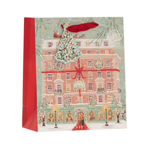 Make your gifts extra special this festive season with our Medium Christmas Shopping Gift Bag from Partisan Products Ltd. This charming bag features a beautifully illustrated festive department store, complete with snowy details, twinkling lights, and a delightful 3D Christmas tree embellishment. Santa even makes an appearance on the rooftop!

With elegant red ribbon handles and a vibrant red side panel, this bag is perfect for adding a touch of magic to any present. Ideal for retailers looking to offer premium gift wrapping, these enchanting bags are sold in a convenient pack of 6. Bring the joy of Christmas to your customers with this wonderfully festive design.