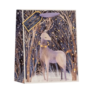 Introduce a touch of winter wonder to your gift-wrapping selection with our Medium Magical Reindeer Gift Bag. This enchanting bag showcases a graceful reindeer, elegantly adorned with a golden star garland, amidst a serene, snow-dusted forest. Twinkling golden stars illuminate the deep blue and purple hues of the winter night, creating a truly captivating scene. Finished with coordinating purple ribbon handles and a charming 'Christmas Wishes' tag, it offers a beautiful and memorable way to present presents. Supplied by Partisan Products Ltd, these delightful bags come in a convenient pack of 6, perfect for your festive retail offering.