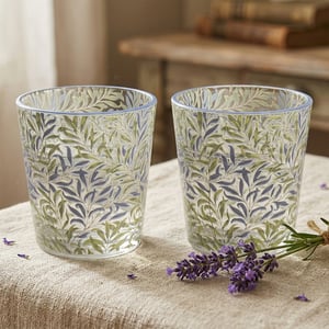 Introduce a touch of timeless elegance to your customers' homes with this exquisite Set Of 2 Willow Bough Glasses from Lesser and Pavey Ltd. Inspired by classic botanical designs, these charming glasses feature a beautiful pattern of intertwining green and soft blue-grey leaves, bringing a serene, nature-inspired aesthetic to any table setting.

Each glass is crafted with care, boasting a delicate light blue rim that perfectly complements the intricate willow bough motif. Ideal for everyday use or special occasions, these versatile glasses are perfect for serving refreshing drinks, from water and juice to cocktails. Sold as a convenient single pack containing two glasses, they make a delightful addition to any homeware collection, promising to be a popular choice for those seeking both beauty and functionality.