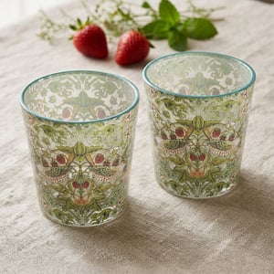 Introduce a touch of timeless elegance to any home with this exquisite Set Of 2 Strawberry Thief Glasses from Lesser and Pavey Ltd. Inspired by William Morris's iconic design, these charming glasses feature an intricate pattern of mischievous birds amidst luscious strawberries and verdant foliage. The vibrant greens and rich reds bring a delightful, nature-inspired aesthetic to your tabletop. Crafted with care, their beautiful detailing makes them perfect for serving refreshing drinks, whether for everyday enjoyment or special occasions. A truly captivating addition to any homeware collection, offering both beauty and functionality.