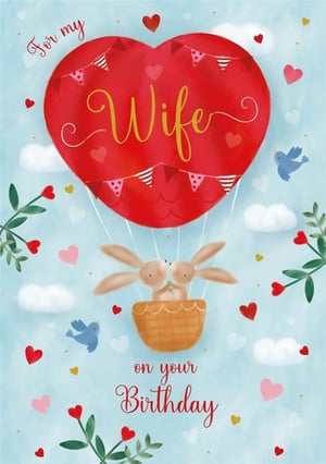 Celebrate her special day with this adorable 'Wife' birthday card from Nigel Quiney Publications. Featuring a charming heart-shaped hot air balloon, complete with sweet bunting, it carries two loving bunnies sharing a kiss. The 'For my Wife on your Birthday' message is beautifully presented against a soft blue sky, adorned with floating hearts and little bluebirds. This delightful watercolour design is perfect for expressing heartfelt affection. Available in a convenient pack of 6, it's a must-have for any card collection.
