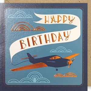 Take flight with this charming 'Open Birthday Male' card from Paper Rose. Featuring a classic vintage-style aeroplane soaring through a serene blue sky, this card is perfect for celebrating any birthday. The elegant 'HAPPY BIRTHDAY' message is beautifully displayed on a flowing white banner, all brought to life with stunning metallic copper foil accents.
The rich blue background, detailed plane, and stylish cloud outlines create a sophisticated and adventurous feel. The tactile foil finish adds a touch of luxury, making this card a distinctive choice. Ideal for customers looking for a high-quality, memorable card for male recipients, this design offers timeless appeal. Stock up on this popular choice, available in a convenient pack of 6, and ensure your shelves are ready for every birthday celebration.