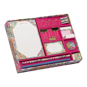 Introduce a burst of floral charm to your customers' desks with the exquisite Liberty Garden Stationery Set, proudly presented by Partisan Products Ltd. Available as singles, this beautifully curated collection is a must-have for any stationery lover. Nestled within a vibrant, floral-patterned box, you'll find a delightful array of essentials. The set includes a lined notepad, elegant gold flower paper clips, practical binder clips, and a dual-hole pencil sharpener. Brighten up notes with floral sticky pads and flags, and enjoy writing with two stylish pens – one adorned with a matching floral design, the other a chic blue polka dot. A floral-sleeved eraser completes this charming and practical ensemble, making it perfect for gifting or personal indulgence.