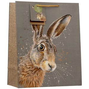 Present gifts beautifully with our Large Wild Hare Gift Bag. This elegant bag features a captivating illustration of a wild hare, brought to life with artistic splatters against a sophisticated grey background. Crafted with attention to detail, it includes a stylish herringbone pattern on the side gussets and a sturdy gold rope handle. An 'Eco-Friendly' tag adds to its appeal, making it a thoughtful choice for any occasion. Perfect for nature lovers, this high-quality gift bag offers a charming way to present presents. Available in a convenient pack of 6, it's an ideal addition to your retail offering.