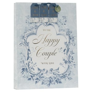 Present wedding gifts with timeless elegance using our Extra Large Wedding Toile Gift Bag. This exquisite bag features a beautiful light blue and white toile design, adorned with intricate floral and foliate patterns, creating a truly sophisticated look. The central message, "TO THE Happy Couple WITH LOVE," is presented in elegant gold script, adding a touch of luxury.
A standout feature is the inclusion of three interchangeable tags: "MRS & MRS," "MR & MR," and "MR & MRS." This thoughtful detail ensures your customers can celebrate any happy couple with the perfect sentiment. Its extra-large size is ideal for accommodating generous wedding presents.
Supplied by Partisan Products Ltd, these premium gift bags come in a convenient pack size of 1x6, making them a perfect addition to your retail offering. Elevate your gift-wrapping selection with this charming and inclusive design.