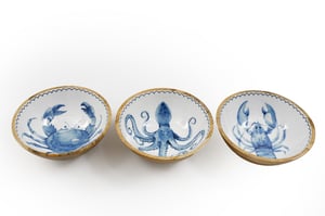 Add a splash of coastal charm to any setting with our delightful 17.5cm Wooden Sealife Enamelled Bowls. This charming set of three features a unique hand-painted style blue sealife design on a crisp white enamelled interior, each finished with a delicate scalloped blue rim. Discover a majestic crab, a playful octopus, and a striking lobster, bringing the wonders of the ocean to your tabletop.

Crafted with a natural wooden exterior, these bowls offer a rustic yet elegant appeal, perfect for serving snacks, dips, or simply as decorative accents. Ideal for adding a nautical flair to kitchens, dining areas, or as a thoughtful gift. Available in a convenient pack of 1x3, these bowls are a must-have for any seaside-inspired collection.