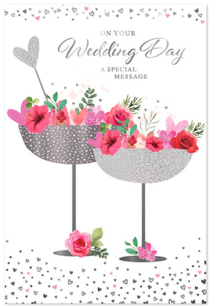 Offer your customers the perfect card for a joyous occasion with our 'Wedding Day' design from Simon Elvin. This elegant card features two shimmering silver champagne coupes, beautifully adorned with vibrant pink flowers, lush foliage, and delicate hearts. A sparkling silver heart adds a celebratory touch, while scattered hearts frame the design. The front proudly displays 'On Your Wedding Day' in a graceful script, with 'A Special Message' awaiting inside. This visually appealing card is ideal for conveying heartfelt congratulations to the happy couple. Available in a convenient pack of 6, it's a wonderful addition to any retail collection, blending romance and sophistication.