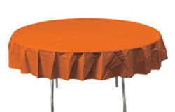 A round table with an orange tablecloth is on it.