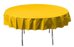 A round table with a yellow tablecloth on it.